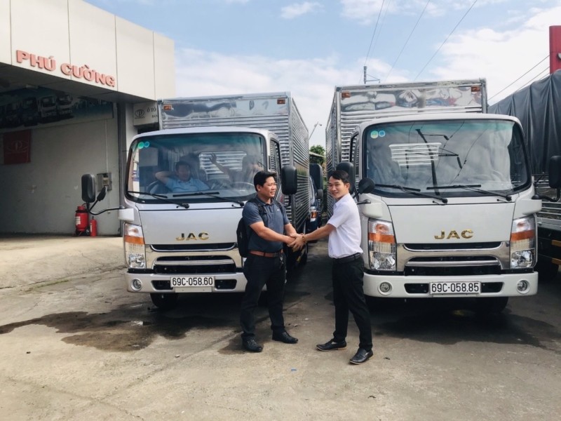 Khách hàng ký hợp đồng mua xe tải Jac tại showroom, minh họa việc áp dụng quy tắc quản lý tài chính là bước không thể thiếu trong cách quản lý xe ô tô.