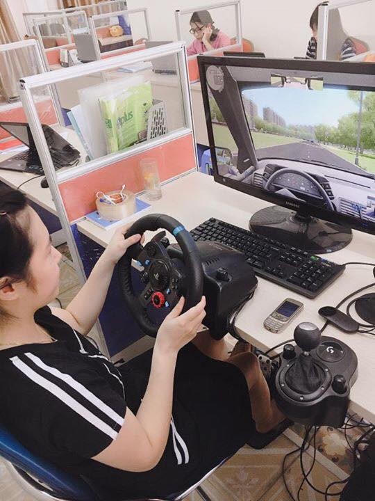 Học viên đang thao tác trên mô hình học lái xe có đầy đủ vô lăng, côn phanh số như xe thật