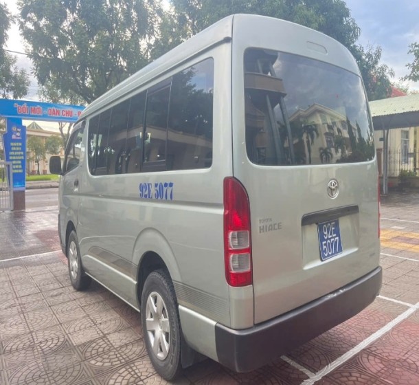 Cận cảnh bánh xe và phần dưới của thân xe khách 16 chỗ Toyota Hiace, cho thấy hệ thống treo và lốp.