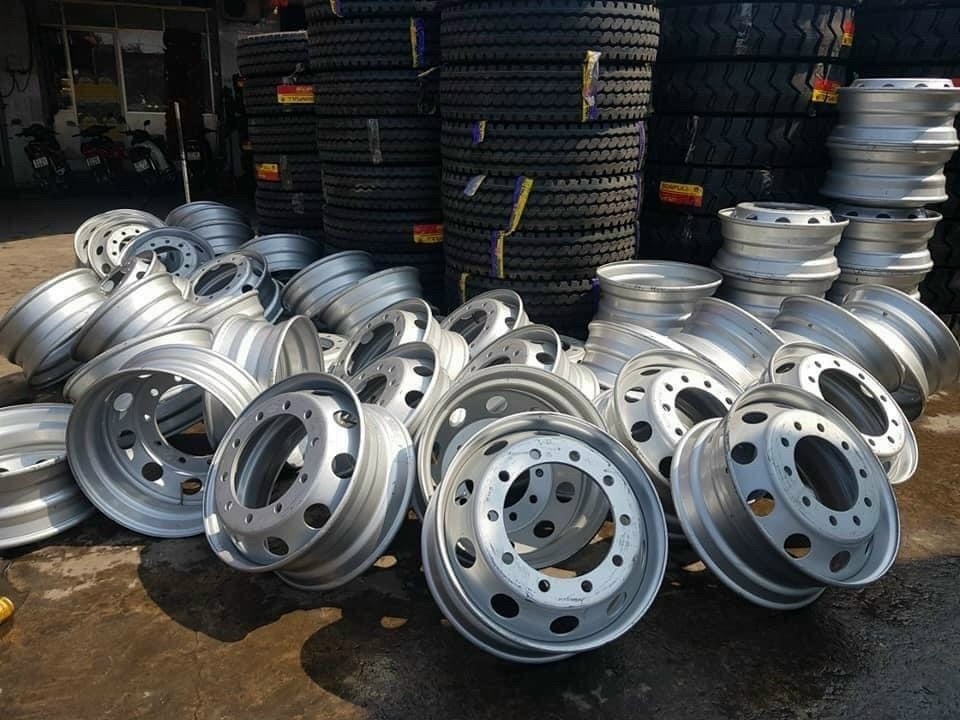 Một nhân viên đang kiểm tra kỹ lưỡng mâm xe ô tô cũ màu bạc