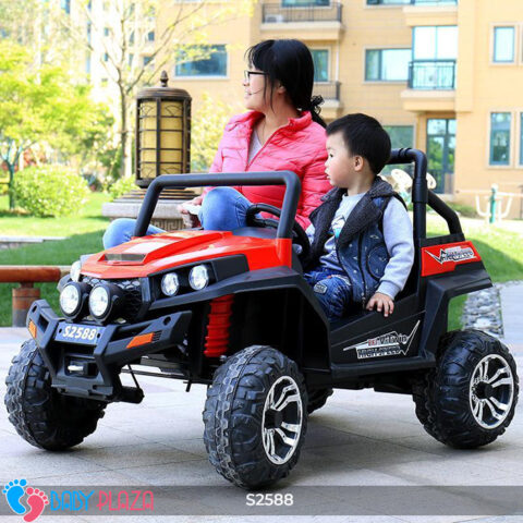 Hai bé trai đang vui vẻ ngồi trên xe ô tô điện S2588 màu vàng cam, thể hiện không gian rộng rãi