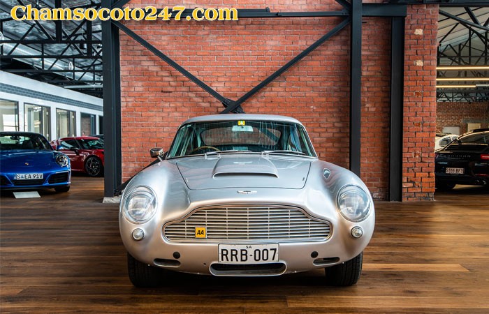 Aston Martin DB5 đang chạy trên đường, phô diễn vẻ đẹp và sự mạnh mẽ.
