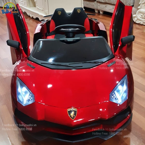 Bé lái xe ô tô điện Lamborghini màu đỏ trên sân vườn