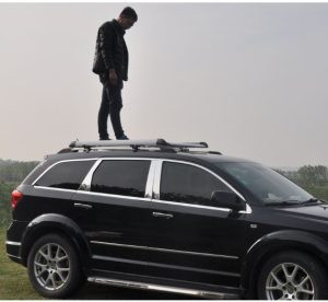 Người đàn ông đang lắp giá để đồ nóc xe ô tô trên chiếc SUV