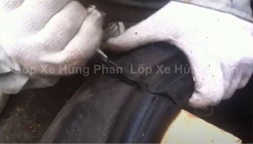 Gọt bỏ phần cao su thừa bằng dao rọc giấy sau khi đã cắt lớp bố thép của lốp xe ô tô