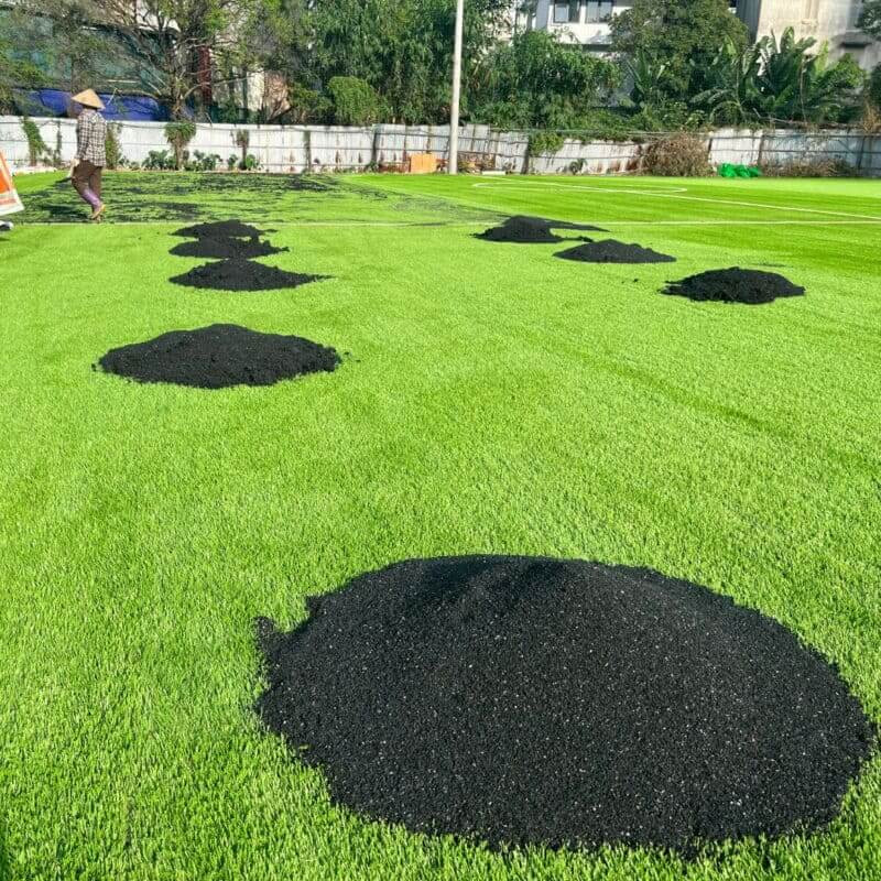 Hạt cao su từ lốp xe tái chế được dùng rộng rãi làm vật liệu cho sân bóng đá và sân chơi, minh họa giá trị của cách cắt lốp xe ô tô đúng cách