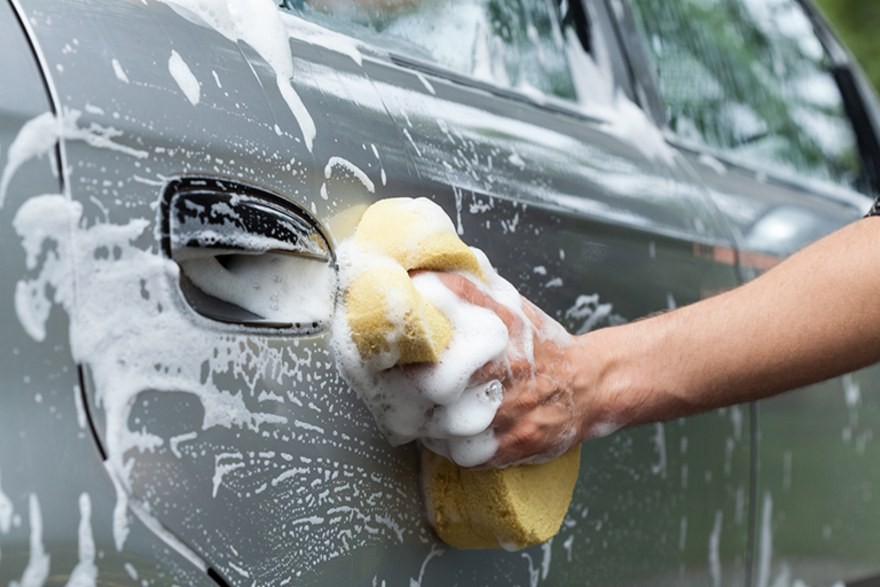Kỹ thuật viên đang vệ sinh hệ thống điều hòa để khử mùi xe ô tô tại garage