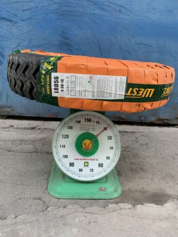 Kỹ thuật viên đang kiểm tra lốp xe ô tô được đặt trên cân