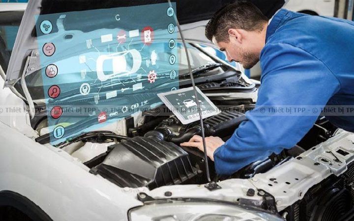 Kỹ thuật viên đang kiểm tra lỗi chuẩn đoán xe ô tô bằng thiết bị chuyên dụng