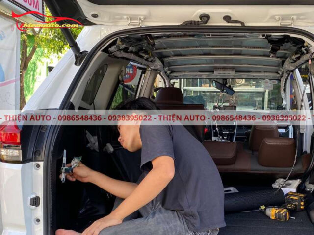 Chuyên viên tỉ mỉ điều chỉnh miếng dán carbon xe ô tô trên thành cốp, đảm bảo độ chính xác