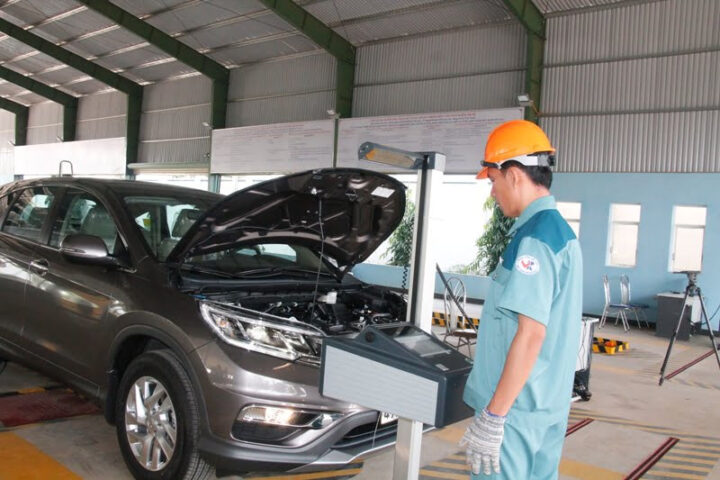 Kiểm định viên đang thực hiện kiểm tra kỹ thuật xe ô tô tại trung tâm đăng kiểm