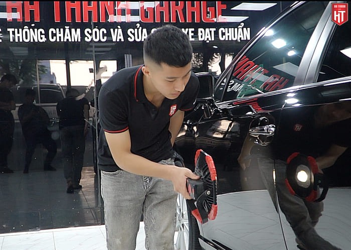 Kỹ thuật viên đang tỉ mỉ vệ sinh nội thất để chăm sóc xe ô tô mới, giữ không gian sạch sẽ