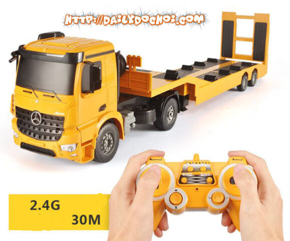 Người lớn điều khiển xe đầu kéo RC qua bộ phát sóng trong sân nhà
