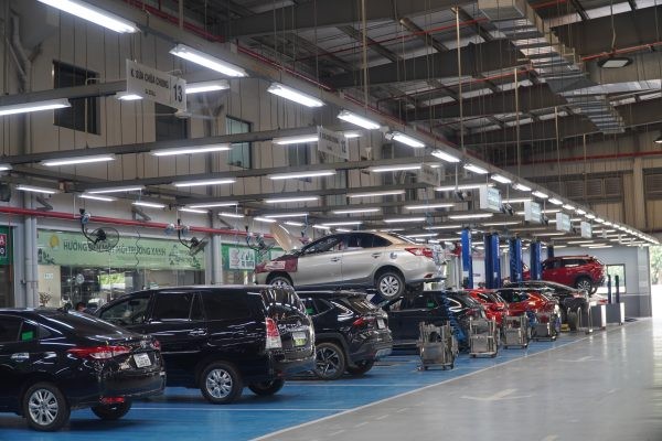 Hình ảnh cận cảnh một chiếc xe ô tô đang được kiểm tra hệ thống gầm, có thể liên quan đến tiếng kêu lạ từ vòng bi bánh xe.