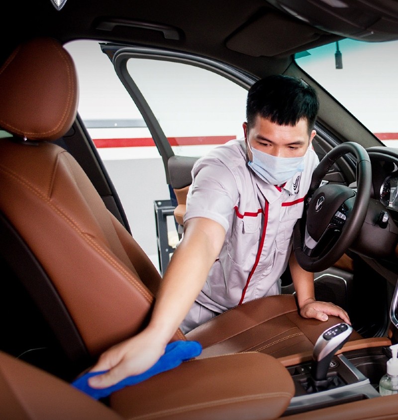 Xịt dung dịch làm sạch lên khăn mềm để giặt nệm xe ô tô da