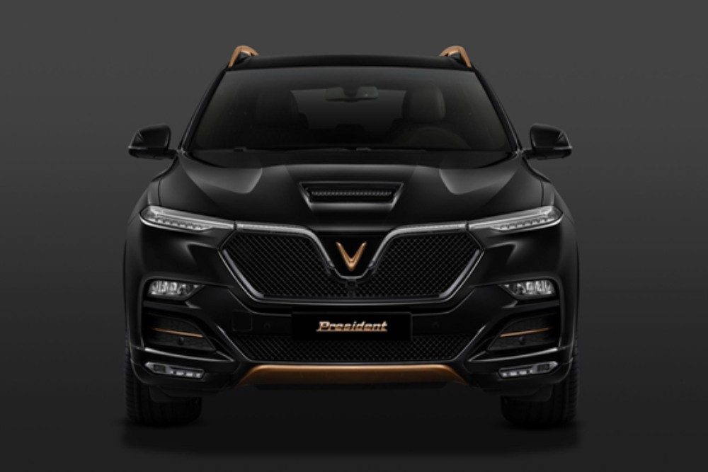Phần đầu xe VinFast President với lưới tản nhiệt hình kim cương và hốc gió lớn, kết hợp logo chữ V, tạo nên vẻ ngoài cuốn hút và đẳng cấp, là một hình ảnh xe ô tô ấn tượng.