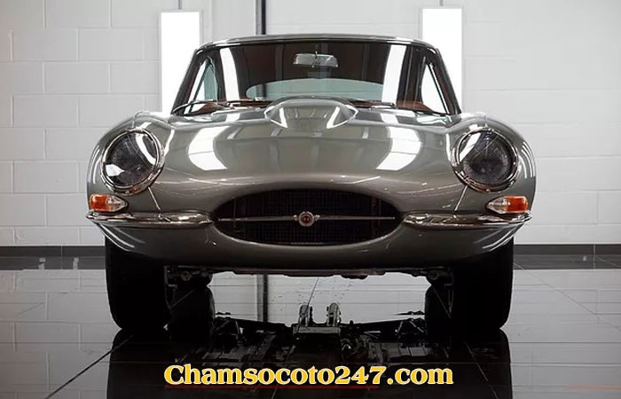 Jaguar E-Type màu xanh lá cây, một trong những chiếc xe cổ đẹp nhất thế giới, đậu bên đường.