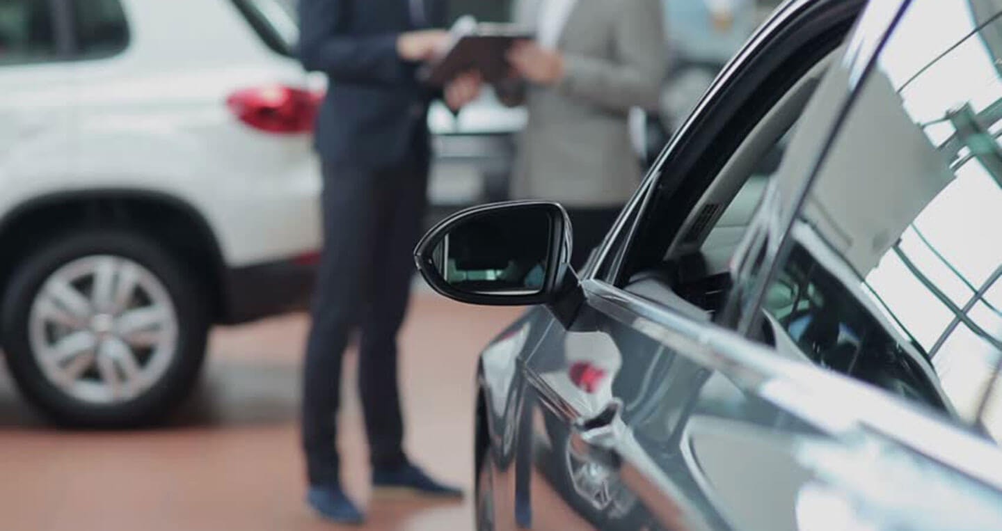 Người lái xe đang kiểm tra lốp xe ô tô tự lái bị xịt, thể hiện tầm quan trọng của kinh nghiệm thuê xe ô tô tự lái Đà Nẵng.
