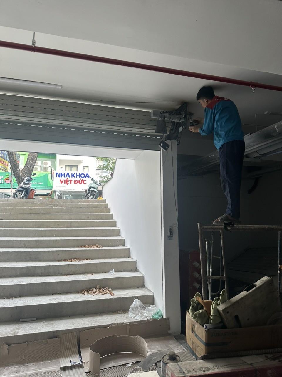 Hình ảnh chuyên gia đang lắp đặt cửa cuốn nhà xe với các dụng cụ chuyên dụng, đảm bảo quy trình an toàn và chất lượng.