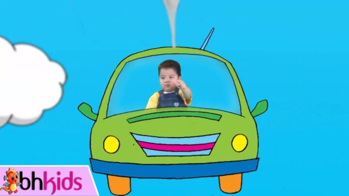 Bé trai đang chơi trò chơi lái xe ô tô ảo với vô lăng và màn hình mô phỏng môi trường lái xe, có tiếng còi po pí po po po