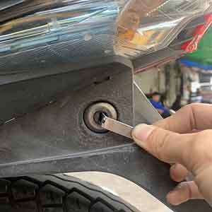 Hình ảnh một người thợ đang mở cốp xe máy
