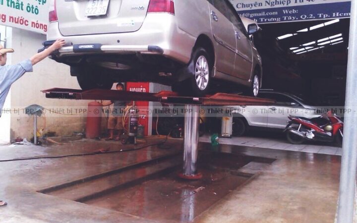 Hình ảnh cầu nâng 1 trụ rửa xe ô tô cũ đang hoạt động tại một trung tâm dịch vụ, minh họa thiết bị cần quan tâm khi mua sắm