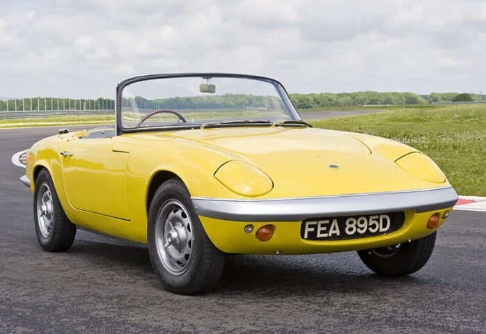 Xe ô tô mui trần cổ Lotus Elan 1963 màu đỏ đang di chuyển trên đường