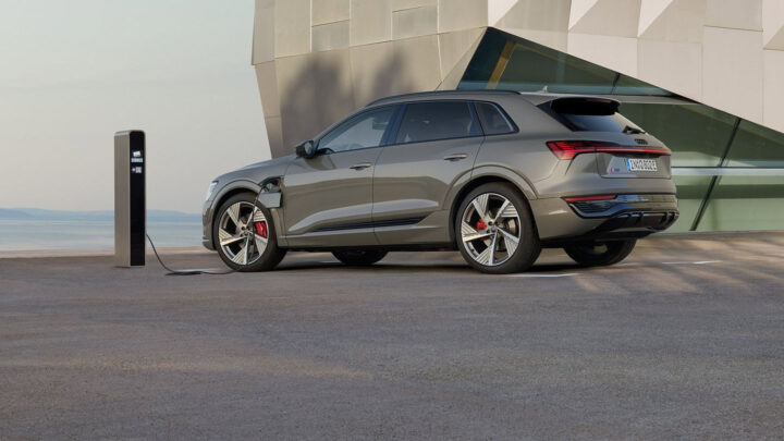 Audi Q8 E-TRON màu trắng đang di chuyển trên đường, thể hiện công nghệ xe điện tiên tiến
