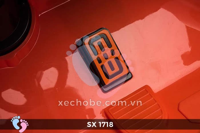 Bé trai ngồi trên xe ô tô điện trẻ em SX 1718 màu đỏ, tạo dáng tự tin