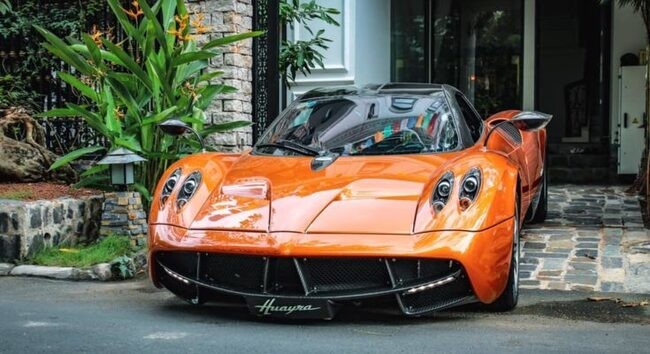 Chiếc xe siêu xe Bugatti Veyron màu đỏ và trắng đỗ trước một tòa nhà hiện đại