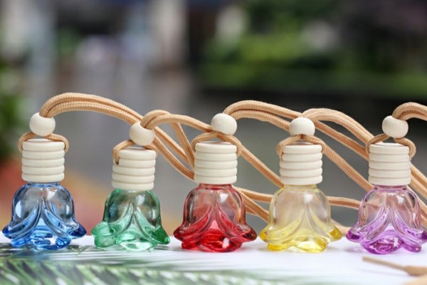 Một lọ tinh dầu treo hình trụ trong xe ô tô, tạo mùi thơm dễ chịu