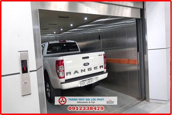 Thang máy tải xe ô tô đang vận chuyển xe màu trắng
