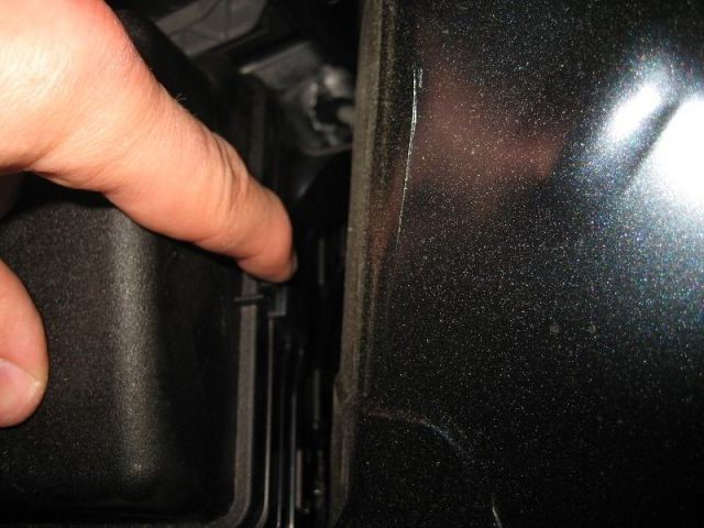 Nhấn chốt bên sườn để tháo nắp hộp cầu chì xe ô tô Camry 2012