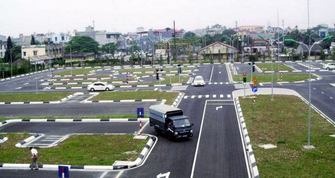 Giáo viên hướng dẫn tập lái xe ô tô bài cho học viên trên đường