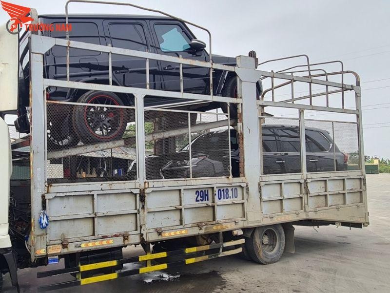 Xe lồng chở nhiều xe ô tô con trên đường, biểu tượng của sự thuận tiện trong vận chuyển xe ô tô