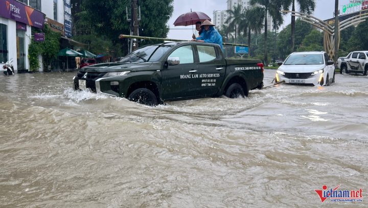 Chuyên viên cứu hộ giao thông hỗ trợ xe bị kẹt giữa dòng nước