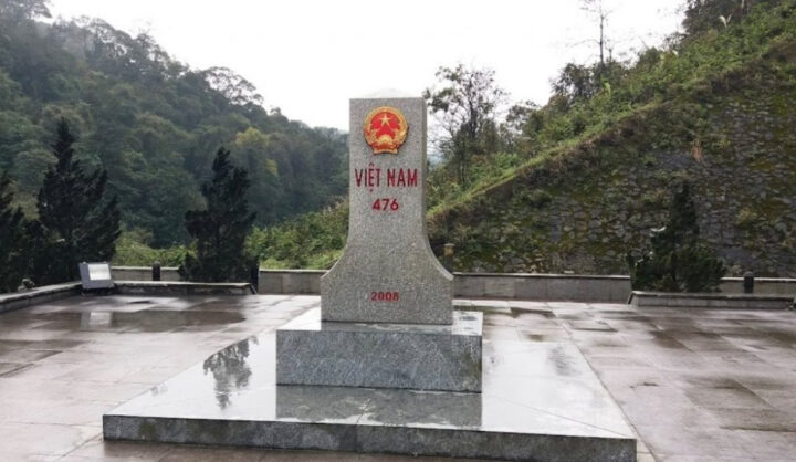 Du khách check-in tại cột mốc 476 trên hành trình du lịch Lào bằng xe ô tô