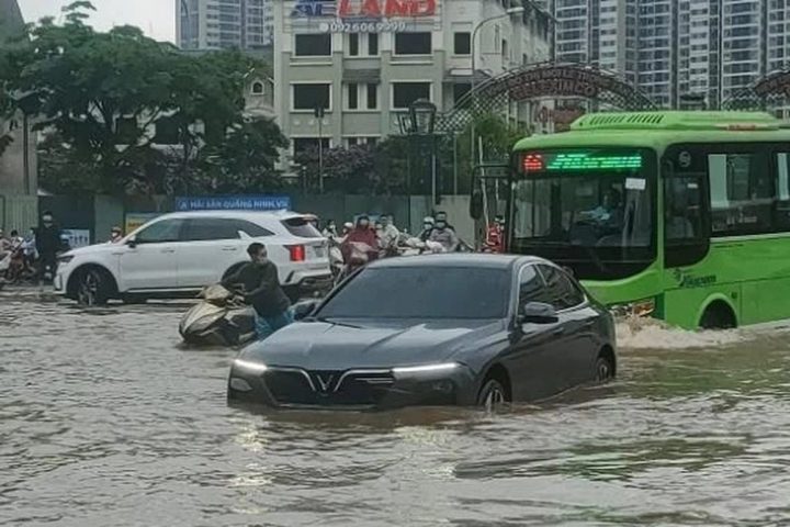 Kỹ thuật viên đang kiểm tra xe ô tô bị ngập nước tại gara, nhấn mạnh tầm quan trọng của việc xử lý đúng cách thay vì cố gắng lái khi xe ngập nước vẫn chạy được.