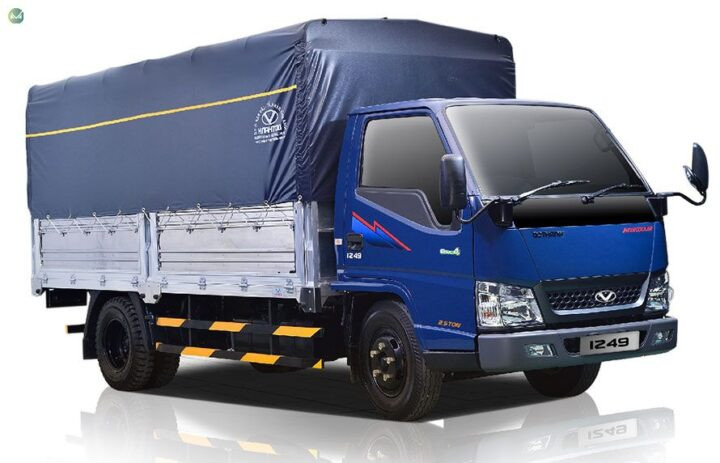 Một xe ô tô tải lớn màu xanh dương di chuyển trên đường cao tốc, thường gặp vào giờ cao điểm như 7 giờ 30 phút sáng