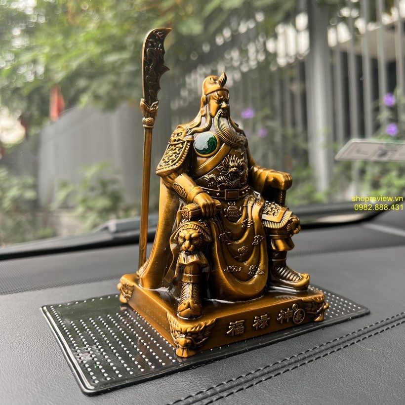 Tượng Quan Công đứng, tay cầm đao, đặt trên taplo xe ô tô sang trọng