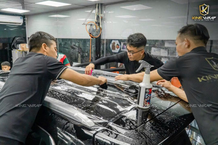 Kỹ thuật viên thực hiện dán PPF kính lái xe ô tô chuyên nghiệp, tỉ mỉ