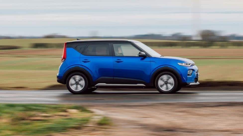 Kia Soul EV màu đỏ di chuyển trên đường vào ban ngày