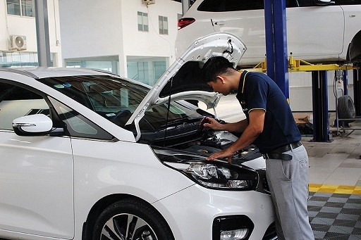 Chuyên gia dịch vụ kiểm tra xe ô tô cũ đang kiểm tra động cơ xe