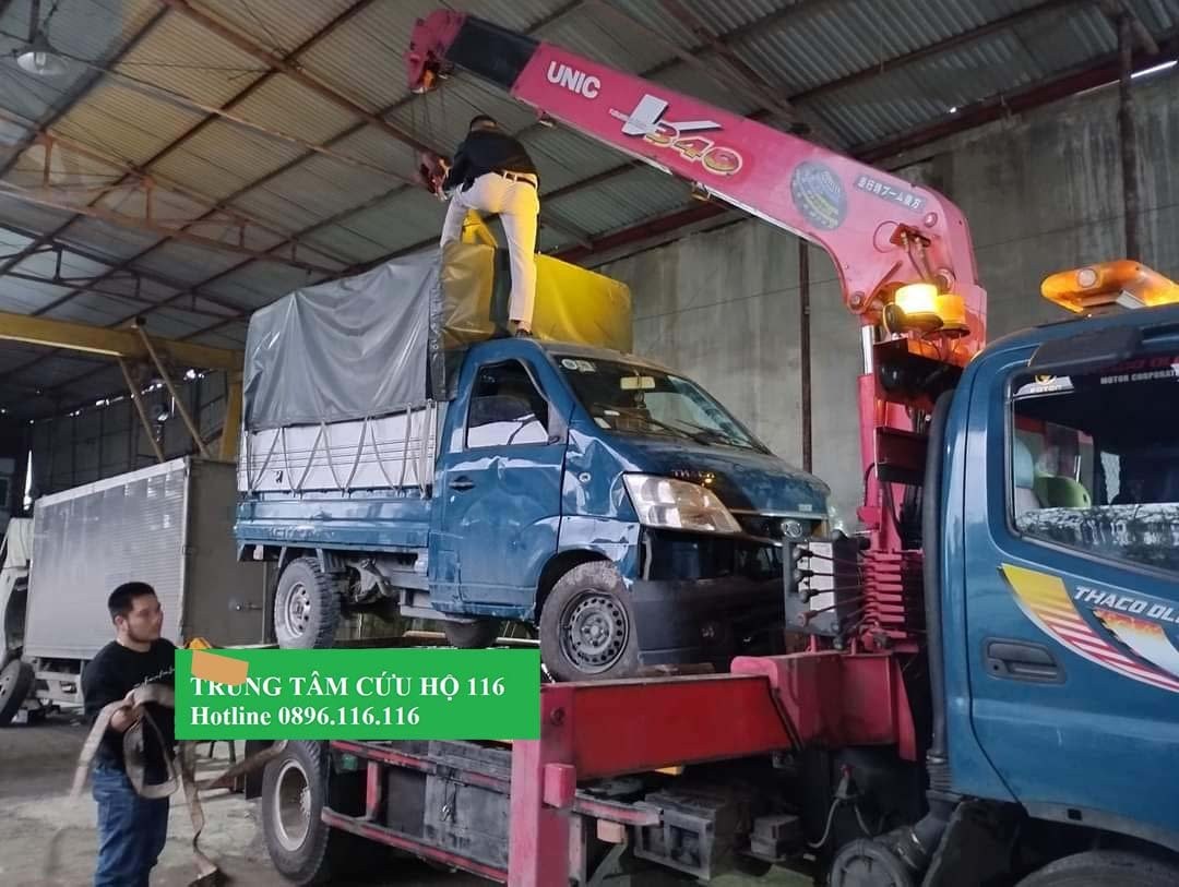 Tài xế đang trao đổi với nhân viên cứu hộ về chi phí dịch vụ sửa chữa xe ô tô