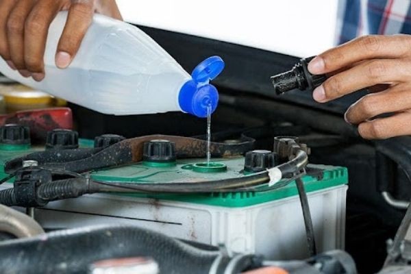 kỹ thuật viên kiểm tra ắc quy xe ô tô bị cạn nước điện dịch