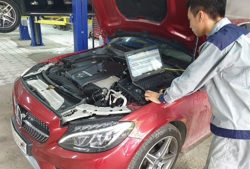 Kỹ thuật viên đang sử dụng máy chẩn đoán để xác định nguyên nhân xe ô tô không bốc