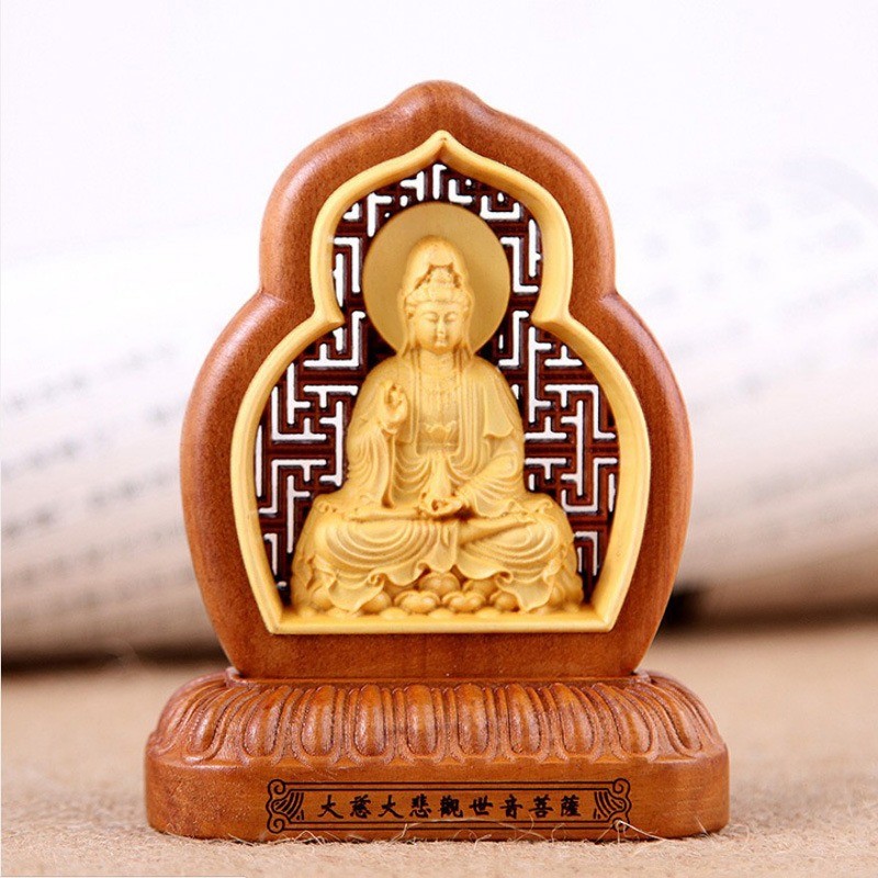Tượng gỗ Phật Bà Quan Âm ngồi thiền trên xe ô tô, mang lại sự bình an và che chở, một trong những vật phẩm phong thủy nên để gì trên xe ô tô.