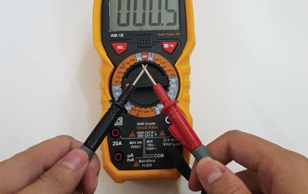 Kết nối đầu dò của đồng hồ vạn năng để kiểm tra tình trạng cầu chì xe ô tô.