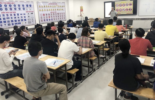 hình ảnh một giáo viên đang hướng dẫn học lý thuyết lái xe ô tô hạng B2 cho học viên