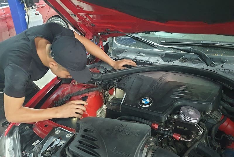 Chuyên gia sử dụng thiết bị chẩn đoán để kiểm tra động cơ xe ô tô không bốc tại gara